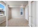 An empty bedroom with neutral carpet, recessed lights, and a bright window at 1727 W 166Th Ave, Broomfield, CO 80023