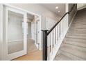 An interior shot of a carpeted staircase with white railing and black bannister at 1727 W 166Th Ave, Broomfield, CO 80023