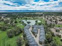 Stunning aerial view showcases the community's serene lake, lush greenery, and mountain backdrop at 2951 W Riverwalk Cir # N, Littleton, CO 80123