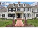 Elegant two-story home featuring classic architectural details, a brick walkway, and manicured lawn at 4682 S Franklin St, Englewood, CO 80113