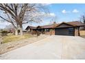 Charming brick home with a well-manicured lawn, mature trees and dark trim at 12674 W 38Th Dr, Wheat Ridge, CO 80033