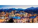 Charming village at dusk with lights, showcasing mountain views and neighborhood charm at 645 S Park Ave # 302, Breckenridge, CO 80424