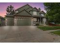 Charming home featuring stone accents, a three-car garage, a covered front porch, and beautiful landscaping at 6296 W Prentice Ave, Littleton, CO 80123