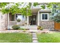 Charming home with a stone-accented facade, inviting porch, and well-manicured lawn at 6296 W Prentice Ave, Littleton, CO 80123