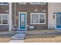 Close-up of townhome entrance with a blue door, brickwork, and modern fixtures at 370 Geneva St, Aurora, CO 80010