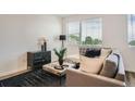 Bright living room with neutral tones, plush seating, and a large window at 370 Geneva St, Aurora, CO 80010