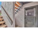 Close up view of the entrance to a two-story condominium with wooden stairs and a security door at 9797 E Peakview Ave # C1, Englewood, CO 80111