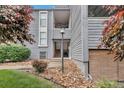 Gray two-story condominium with stone accents and a walkway leading to the entrance and mature landscaping at 9797 E Peakview Ave # C1, Englewood, CO 80111
