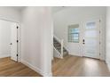 Bright entryway with hardwood floors, white trim, a staircase, and a front door with sidelights at 42964 Colonial Trl, Elizabeth, CO 80107