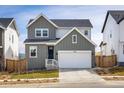 Charming two-story home with gray siding, a white garage door, and well-maintained landscaping at 16568 W 92Nd Pl, Arvada, CO 80007