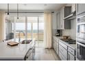 Bright kitchen with quartz countertops, stainless appliances, and a sliding glass door with beautiful views at 16568 W 92Nd Pl, Arvada, CO 80007