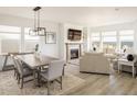 Open-concept living and dining area with modern lighting, fireplace, and large windows with great views at 16568 W 92Nd Pl, Arvada, CO 80007