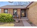Cozy front porch with seating area, brick facade, and charming curb appeal at 2158 S Elkhart St, Aurora, CO 80014