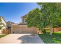 Two story home with a three car garage, well maintained lawn, and mature landscaping at 5534 S Wenatchee St, Aurora, CO 80015