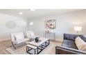 Well-lit living room boasts modern furniture, clean lines, and a neutral color palette for a sophisticated look at 1476 W Dakota Ave, Denver, CO 80223