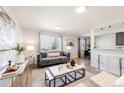 Cozy living room with contemporary furnishings, large windows, and an open layout leading to the dining area at 1476 W Dakota Ave, Denver, CO 80223