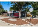 Charming two-story home with beautiful front yard landscaping, a vibrant red garage door, and mature trees at 12555 W 61St Ave, Arvada, CO 80004