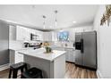 Well-lit kitchen with white cabinets, stainless steel appliances, and a convenient island, perfect for cooking and casual dining at 12555 W 61St Ave, Arvada, CO 80004