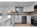 Bright kitchen features white cabinetry, stainless steel appliances, and stylish backsplash at 12635 E Pacific Cir # A, Aurora, CO 80014