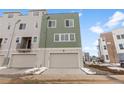 Modern townhome featuring a two-car garage, neutral siding, and a well-kept front lawn at 14283 Currant St, Broomfield, CO 80020