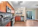 Well-lit kitchen with granite countertops, stainless steel appliances, and wood cabinetry at 1272 S Crystal Way, Aurora, CO 80012