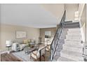 Comfortable living area with stylish furniture, a patterned rug, and a staircase at 1272 S Crystal Way, Aurora, CO 80012