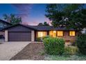 Charming single Gathering home featuring a two car garage, beautiful plants, and exterior brick work at 7382 E Bates Dr, Denver, CO 80231