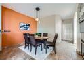 Elegant dining room featuring an accent wall, modern lighting, and tile flooring at 3109 Newport Cir, Castle Rock, CO 80104
