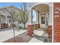 Inviting front porch with brick accents and scenic views creates a warm welcome at 3109 Newport Cir, Castle Rock, CO 80104