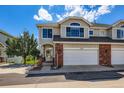 Inviting two-story townhome exterior boasting brick accents, an attached garage, and well-maintained landscaping at 3109 Newport Cir, Castle Rock, CO 80104