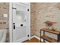 Welcoming foyer with a rustic door, exposed brick wall, and decorative wooden shelf at 4301 Zuni St, Denver, CO 80211