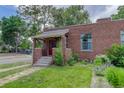 Charming single-story brick home featuring a cozy front porch and manicured lawn at 4301 Zuni St, Denver, CO 80211