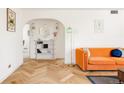 Inviting living room featuring hardwood floors, orange couch, and eye-catching décor at 1010 N Jasmine St, Denver, CO 80220