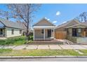 Street view showcasing the cute beige exterior, a small covered porch, and grassy yard at 4636 Leaf Ct, Denver, CO 80216