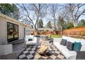 Inviting backyard with patio furniture, a fire pit, a well-manicured lawn, and privacy fencing at 3206 S Clayton St, Denver, CO 80210