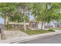 Traditional two-story home with brick accents, lush lawn, and mature trees creating a welcoming curb appeal at 5241 E 111 Th Ct, Thornton, CO 80233