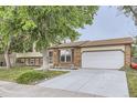 Well-maintained two-story home featuring a brick facade, attached two-car garage, and a neatly landscaped front yard at 5241 E 111 Th Ct, Thornton, CO 80233