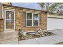 Close-up of the home's entrance, showcasing the brick detail, front door, and manicured landscaping at 5241 E 111 Th Ct, Thornton, CO 80233