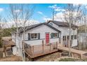 Charming exterior with a well-maintained deck and a bright red front door at 11987 W Ranch Elsie Rd, Golden, CO 80403