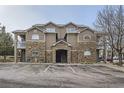 Exterior facade of building with stone accents, private balcony and convenient parking spots at 7440 S Blackhawk St # 15-202, Englewood, CO 80112