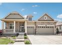 Charming, two-story home featuring stone accents, a covered porch, and an attached two-car garage at 27196 E Alder Dr, Aurora, CO 80016