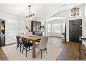 Bright dining room with wood table, bench, hutch, and entryway view at 5935 E 129Th Pl, Thornton, CO 80602