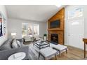 Bright living room with vaulted ceilings, modern furniture and wooden fireplace with mounted television at 7722 S Steele St, Centennial, CO 80122