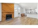 Open-concept living room with a wooden fireplace and access to the kitchen and entryway at 7722 S Steele St, Centennial, CO 80122