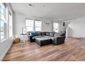 Bright and airy living room with a comfortable sectional couch and hardwood floors at 28304 E 6Th Pl, Watkins, CO 80137