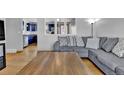 Comfortable living room with a plush gray sectional and hardwood floors at 6434 S Dudley Way, Littleton, CO 80123