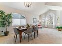 Dining room featuring a wooden table with gray upholstered chairs and a large arched window at 10470 W Cooper Pl, Littleton, CO 80127