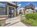 Modern townhome front entrance with brick planter and a black metal awning at 6849 E Lowry Blvd, Denver, CO 80230