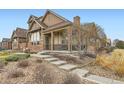 Attractive home exterior with stone accents, covered porch, and well-maintained landscaping at 555 Gallegos Cir, Erie, CO 80516
