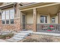 Inviting front porch with stylish railings, stone accents, and a cozy seating area at 555 Gallegos Cir, Erie, CO 80516